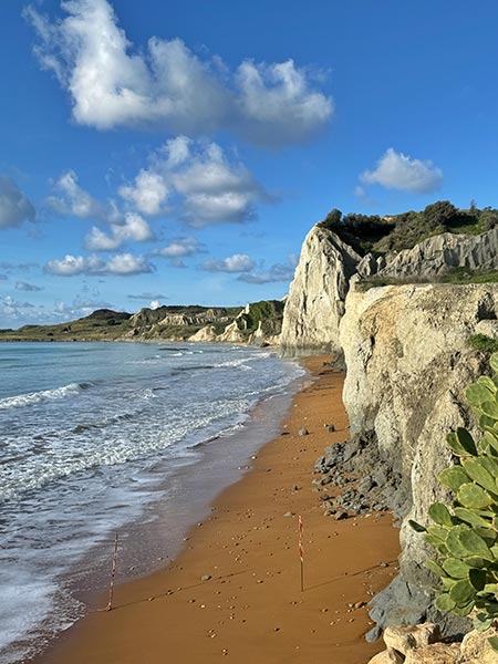 Xi Beach es una playa con arena rojiza, y acantilados blancos