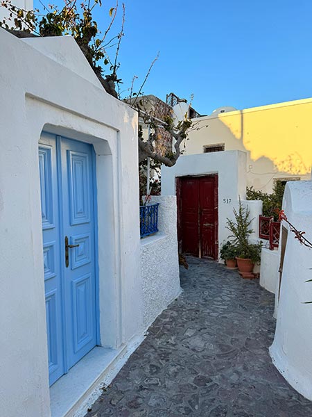 Calle detrás de los molinos de viento de Oia
